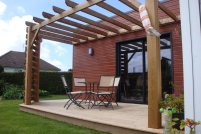 Une pergola adossée sur un bardage en bois